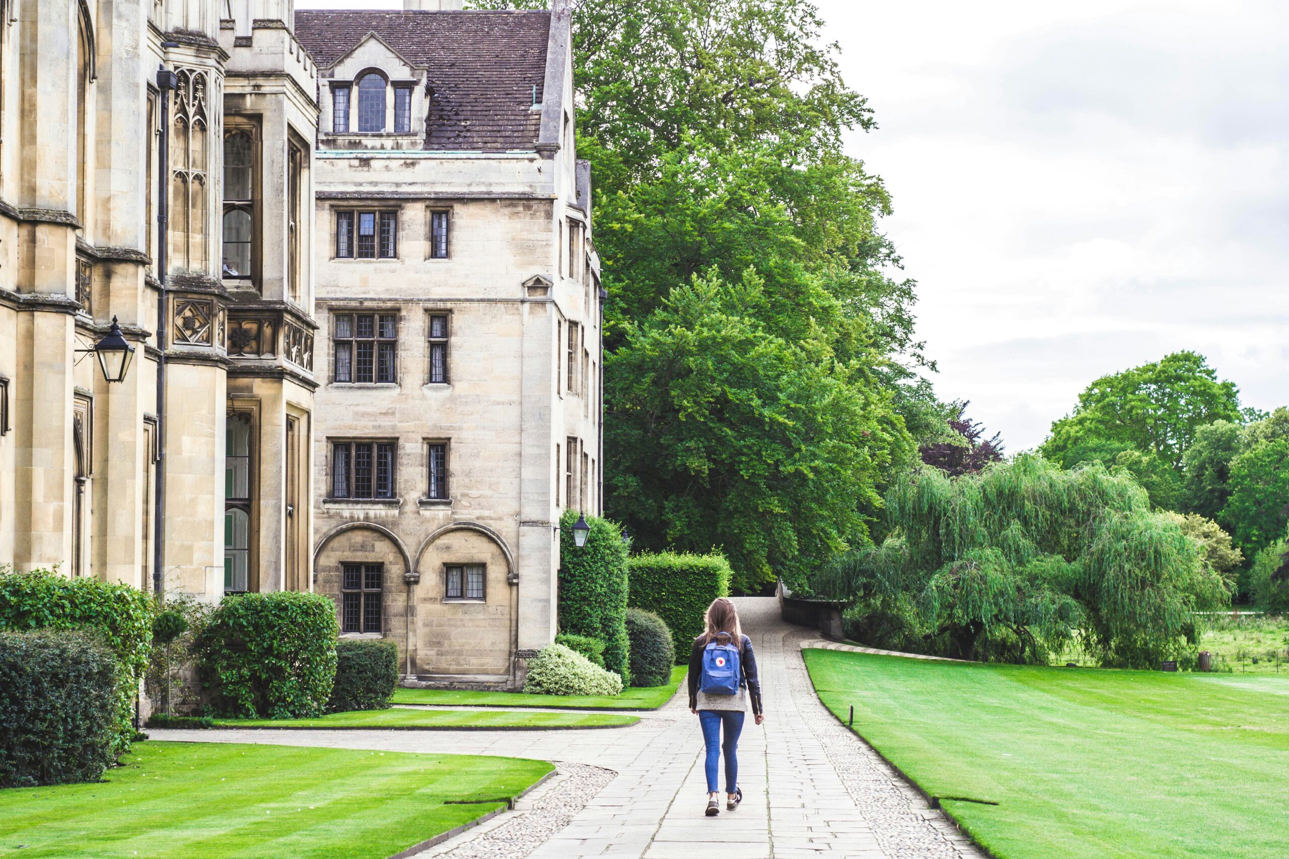 Student walking past a historic university building